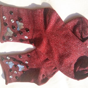 May include: A pair of red sparkly socks with silver butterfly embellishments and black rhinestones.