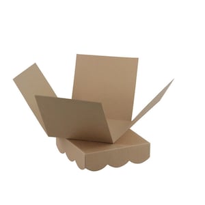 May include: A brown cardboard gift box with a scalloped edge design. The box is open, with the top flaps partially extended, revealing the interior. The box is made of a plain, unprinted cardboard material.