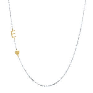 May include: A silver chain necklace with a gold letter "E" charm and a gold heart charm.