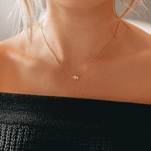 May include: A gold necklace with a small elephant pendant.