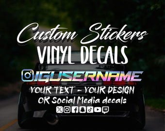 May include: Custom Stickers Vinyl Decals with the text "IGUSERNAME" and the words "YOUR TEXT - YOUR DESIGN OR Social Media decals" in white text on a black background. The image shows a car with a sticker on the back window.