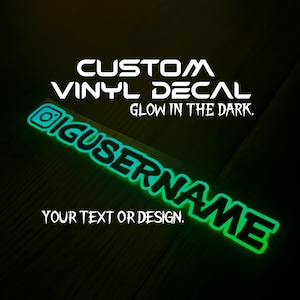 May include: Custom vinyl decal that glows in the dark. The decal features the text "CUSTOM VINYL DECAL GLOW IN THE DARK" and the text "YOUR TEXT OR DESIGN".