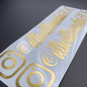 May include: Two gold Instagram icons with the text "@illuminate716" and "@illuminate716" written in a cursive font.