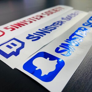May include: Three rectangular vinyl stickers with white backgrounds. The first features a red Instagram logo and the text SINISTER SOCIETY. The second has a blue Twitch logo and text. The third displays a blue Snapchat logo and text.