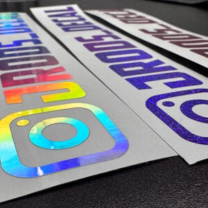 May include: Three rectangular adhesive decals featuring the Instagram logo and the text "IGRODS_DECAL". The decals have a reflective, holographic finish that shifts between rainbow colors, purple, and dark tones, applied to a white backing paper.