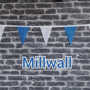 May include: A brick wall with a blue and white bunting strung across it. The word "Millwall" is written in blue letters below the bunting.