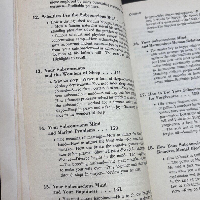 May include: Open book with text about the subconscious mind and related topics. The pages are yellowed with age, and the text is in black. Topics include sleep, marital problems, and happiness.