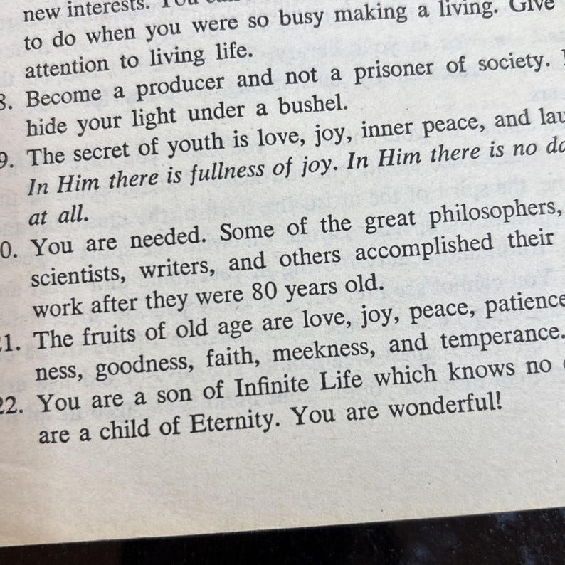 May include: Close-up of a printed page with inspirational text. The text includes phrases about living life, joy, and the fruits of old age. The paper is off-white with black text.