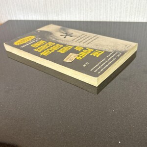 May include: A paperback book titled "The Power of Your Subconscious Mind" with a yellow and black cover. The book has a price sticker on the front and is lying on a dark surface.