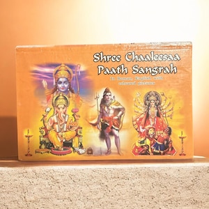 May include: A rectangular book titled Shree Chaaleesaa Paath Sangrah in Roman, English with coloured pictures. The orange cover features illustrations of Hindu deities including Ganesha, Shiva, and Durga, with small lamp icons on the sides.