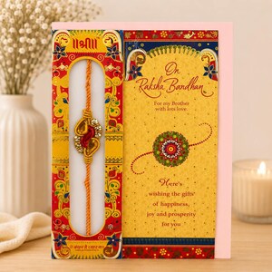 May include: A Raksha Bandhan greeting card featuring a yellow and red decorative border with a central cutout displaying a gold thread bracelet with red and clear stones. The card includes the text On Raksha Bandhan For my Brother with lots love.