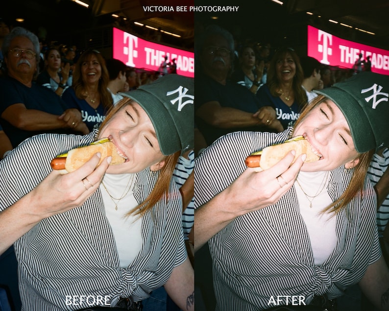 May include: A woman wearing a black and white striped shirt and a black baseball cap with a white NY logo is eating a hot dog at a baseball game. The text "THE LEADER" is visible on a sign behind her.