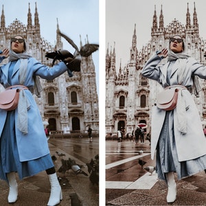 May include: A woman wearing a light blue coat, a light blue headscarf, and white boots stands in front of a large cathedral. She is holding a pink fanny pack and a bird is perched on her hand.