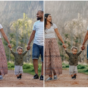 May include: A family of three walks along a path in a wooded area. The parents are holding hands with their young child. The parents are wearing casual clothing, while the child is wearing a green shirt and gray shorts. The background is a blurred image of trees and foliage.