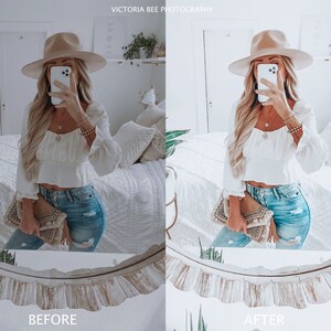 May include: A woman wearing a white crop top, blue jeans, and a wide-brimmed hat is taking a selfie in a mirror. She is holding a brown clutch purse.