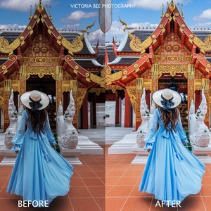 May include: A woman in a light blue dress and a white hat stands in front of a traditional Thai temple with intricate carvings and a red roof. The temple is decorated with gold accents. The woman is facing away from the camera and her dress is flowing in the wind.