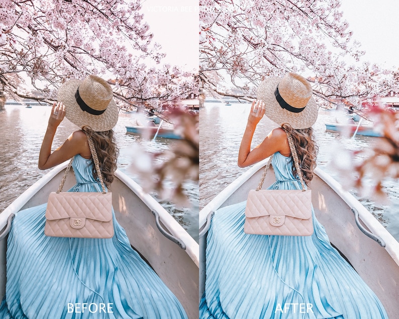 May include: A woman in a blue dress and a straw hat sits in a boat on a lake. The lake is surrounded by cherry blossom trees. She is holding a beige quilted handbag.