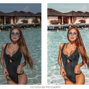 May include: A woman wearing a black one-piece swimsuit with a bow detail and sunglasses, standing in a pool of water. The background features a tropical resort with palm trees and buildings.