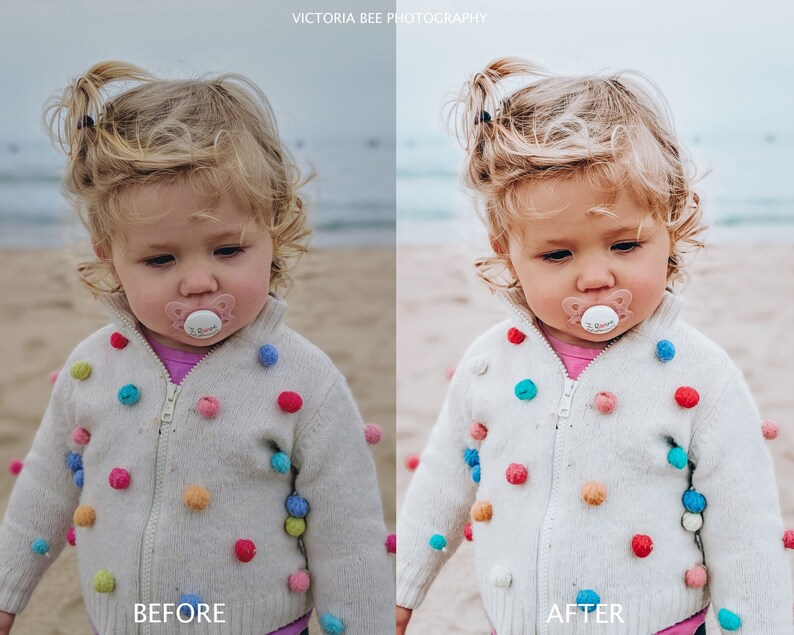 May include: A young child wearing a white sweater with colorful pom-poms and a pink pacifier. The child has blonde hair and is standing on a sandy beach.
