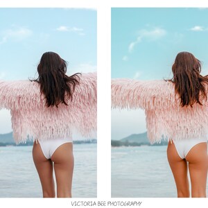 May include: A woman wearing a pink fuzzy jacket and white bikini bottoms stands with her arms outstretched on a beach. The sky is blue and the water is a light blue.