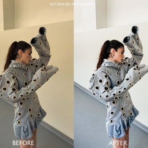 May include: A woman wearing a light blue denim jacket with a floral pattern. The jacket has large, exaggerated sleeves. The woman is standing in front of a white wall.