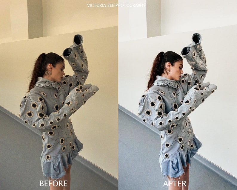 May include: A woman wearing a light blue denim jacket with a floral pattern. The jacket has large, exaggerated sleeves. The woman is standing in front of a white wall.