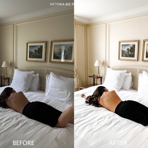 May include: A woman lies on a white bed with white pillows and a white bedspread. The bed is in a room with beige walls and two framed landscape paintings on the wall. The woman is wearing a black skirt and has long dark hair.
