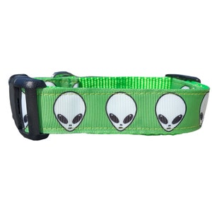 May include: Green dog collar with a repeating pattern of white alien faces.