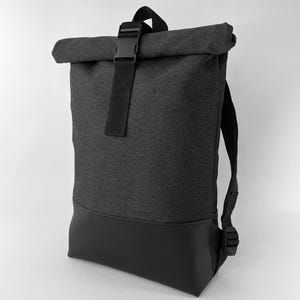 May include: A black and gray backpack with a roll-top closure and a black buckle. The bottom section is made of a smooth, black material. The backpack has adjustable shoulder straps.