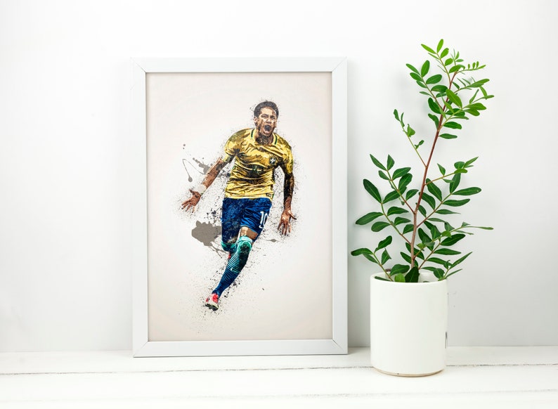 May include: A framed print of a soccer player in a yellow and blue uniform, running with the ball, against a white background with paint splatters.