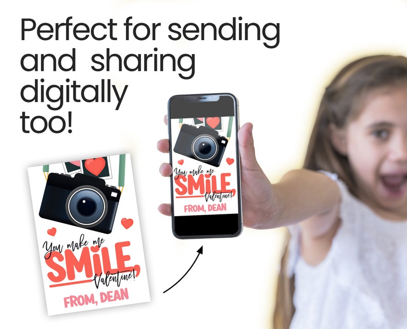 Peut inclure: Une carte de Saint-Valentin et un smartphone affichant un design similaire. La carte et l'&eacute;cran du t&eacute;l&eacute;phone pr&eacute;sentent un appareil photo noir, des coeurs rouges et le texte "You make me SMILE Valentine! FROM, DEAN."