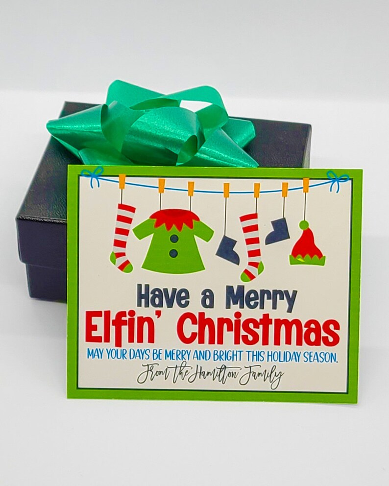 May include: A green and white gift card with a Christmas elf design. The card reads "Have a Merry Elfin' Christmas" and "May your days be merry and bright this holiday season. From the Hamilton Family."