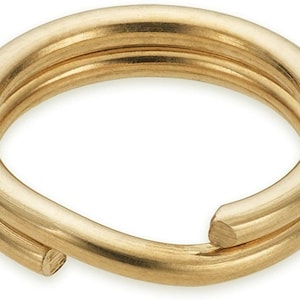 May include: A gold-colored metal key ring with a double loop design. The ring is made of a single piece of metal that is bent into a circle and then twisted to create the double loop.