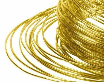 Puede incluir: Primer plano de un carrete de alambre de color dorado. El alambre está enrollado firmemente alrededor del carrete, creando una superficie lisa y continua.