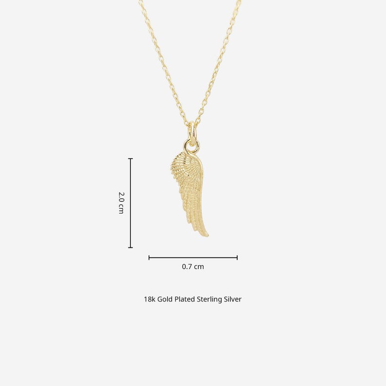 May include: A gold-colored pendant necklace featuring a detailed wing design. The wing pendant measures 0.7 cm wide and 2.0 cm long. The necklace is made of 18k gold plated sterling silver.
