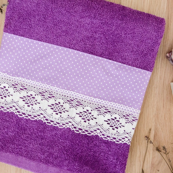 Purple decorative bath towel with purple dots fabric and a lace trim.