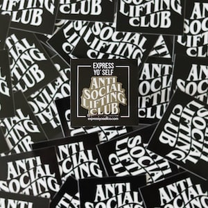 May include: A gold-colored pin with the text "Anti Social Lifting Club" in a curved, stylized font. The pin is surrounded by black and white stickers with the same text.