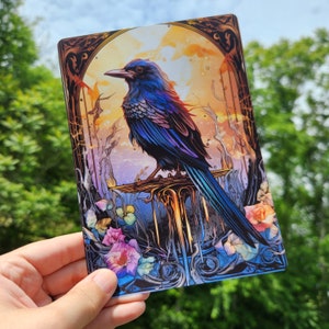 May include: A blue and purple bird with a long tail perched on a branch with a golden background. The bird is surrounded by flowers and leaves.