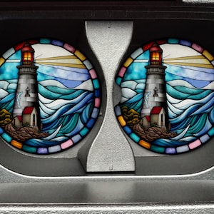 May include: Two round coasters with a stained glass design of a lighthouse on a stormy sea. The coasters feature a blue, green, yellow, orange, and pink color scheme.