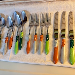 May include: A set of stainless steel flatware including six spoons, four forks, and four knives. Each piece features a decorative handle with a sculpted, leaf-like design in various shades of green, orange, and cream, with a glossy finish.
