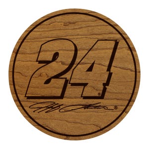 May include: A round wooden plaque with the number "24" in a bold, stylized font. The plaque features a dark brown border and a light brown wood grain background. Below the number is a signature.