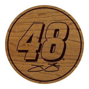May include: A round wooden coaster with a dark brown border and a light brown wood grain background. The number "48" is prominently displayed in a bold, dark brown font. Below the number are two stylized lines.