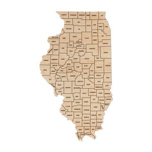 May include: A wooden map of Illinois with each county outlined and labeled. The map is made of light brown wood and the county names are printed in black.