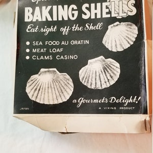 May include: A box of white baking shells with a black and white illustration of the shells. The box reads "Epicure Baking Shells Eat right off the Shell" and lists three uses: "Sea Food Au Gratin", "Meat Loaf", and "Clams Casino". The box also reads "a Gourmet's Delight! A Viking Product" and "Japan".
