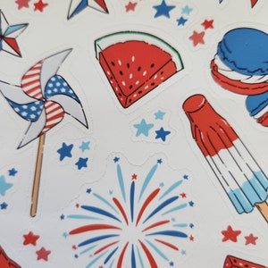 May include: A set of red, white and blue stickers featuring a slice of watermelon, a pinwheel, fireworks, a popsicle and a macaron. The stickers are ideal for adding a festive touch to any project.