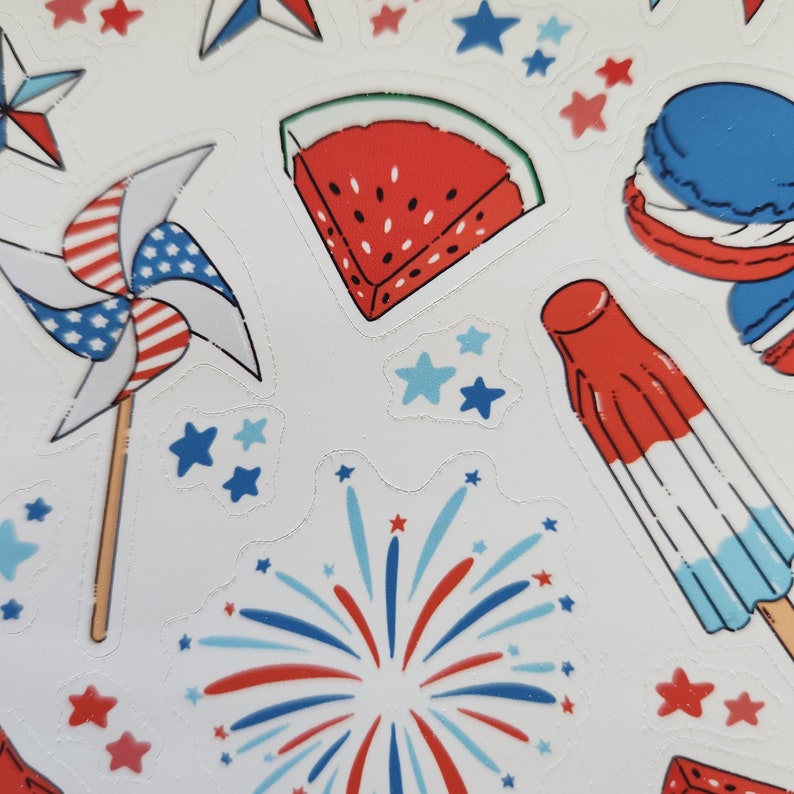 May include: A set of red, white and blue stickers featuring a slice of watermelon, a pinwheel, fireworks, a popsicle and a macaron. The stickers are ideal for adding a festive touch to any project.