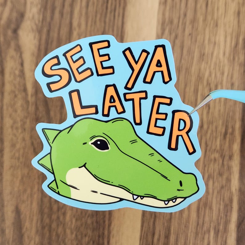 May include: A sticker with a cartoon alligator head and the words "SEE YA LATER" in orange letters on a light blue background. The alligator is green with a white belly and a smiling expression.