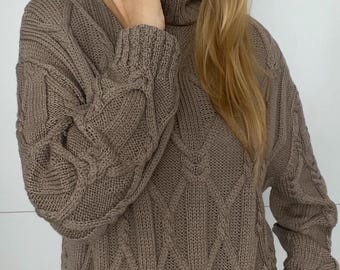 Cálido suéter de cuello alto hecho a mano con arans y cordones de lana merino.