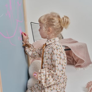 blue arch magnetic chalkboard with natural wood frame in a kids room