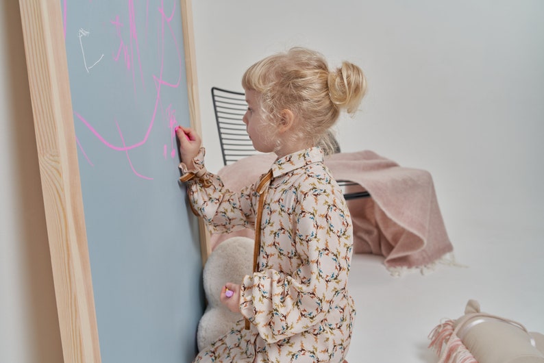 blue arch magnetic chalkboard with natural wood frame in a kids room